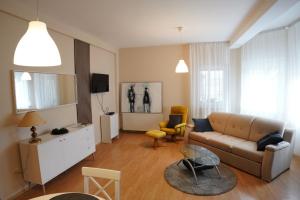 una sala de estar con un sofá y una mesa en Apartmani Kula, en Novi Banovci