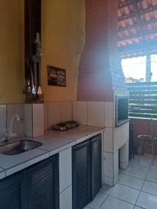 a kitchen with a sink and a counter top at Sunshine Residencial in Bombinhas