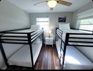 two bunk beds in a room with a ceiling fan at Just Beachy Sleeps 10 in Wildwood Highlands Beach