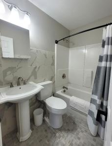 a bathroom with a toilet and a sink and a tub at Just Beachy Sleeps 10 in Wildwood Highlands Beach +10 photos