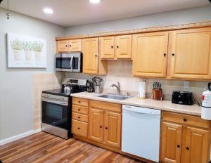 a kitchen with wooden cabinets and a white appliance at Just Beachy Sleeps 10 in Wildwood Highlands Beach