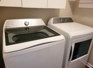 a white stove top oven next to a washing machine at Just Beachy Sleeps 10 in Wildwood Highlands Beach