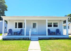 a blue house with chairs on the front porch at Just Beachy Sleeps 10 in Wildwood Highlands Beach