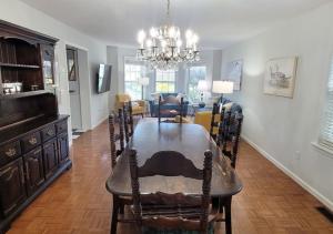 a dining room and living room with a table and chairs at Tranquil Gardens Cape May Private Beach Steps Away in Cape May