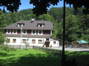 una grande casa bianca con il tetto nero di Hotel Säntis a Komorní Lhotka