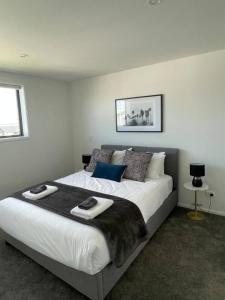 基督城Lovely Mohua Sanctuary的卧室里有一张大床，床上铺着毛巾。