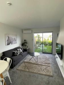 基督城Lovely Mohua Sanctuary的客厅里有一张沙发和一张桌子。