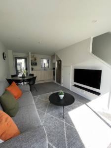 ein Wohnzimmer mit Couch und Flachbildfernseher in der Unterkunft Mohua Lane Retreat in Christchurch