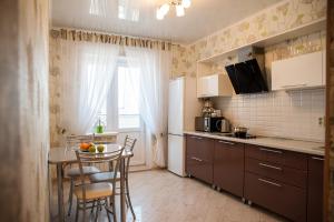 ペンザにあるApartment Ternopolskaya 18のキッチン(テーブル、椅子、冷蔵庫付)