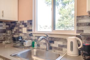 a kitchen counter with a sink and a window at Near Hiking and Golf Cozy Cottage in Morgan Hill! in Morgan Hill