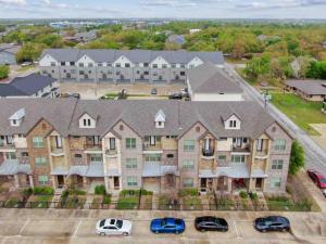 an apartment building with cars parked in a parking lot at Northgate Nest Townhome 2 BR 2.5 BA Office Walk to TAMU in Bryan