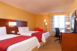 a hotel room with two beds and a desk at Hotel Pentagon South in Alexandria