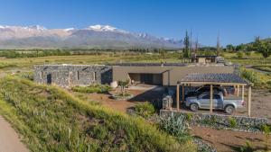 a house with a truck parked in front of it at Rancho Adobe Eco Hotel in Tupungato