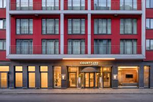 a red building with a store in front of it at Courtyard by Marriott Munich City Center in Munich