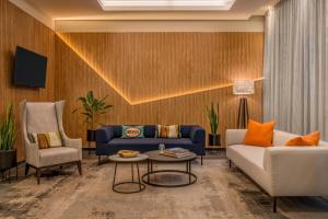 a living room with a couch and a chair at Courtyard by Marriott Munich City Center in Munich