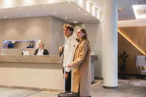 a man and a woman standing in front of a counter at Courtyard by Marriott Munich City Center in Munich