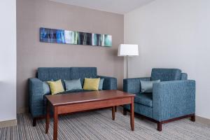 a living room with two blue chairs and a coffee table at Courtyard by Marriott Munich City Center in Munich