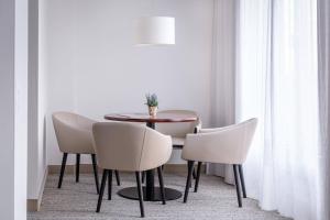 a dining room with a table and white chairs at Courtyard by Marriott Munich City Center in Munich