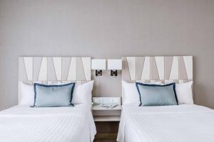 two beds with blue pillows in a hotel room at Courtyard by Marriott Munich City Center in Munich