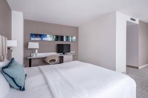 a bedroom with a bed and a desk with a tv at Courtyard by Marriott Munich City Center in Munich