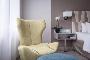 a bedroom with a chair and a bed and a table at Courtyard by Marriott Munich City Center in Munich
