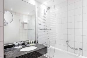 a bathroom with a sink and a shower at Courtyard by Marriott Munich City Center in Munich
