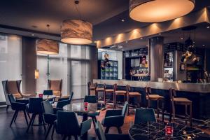 a restaurant with tables and chairs and a bar at Courtyard by Marriott Munich City Center in Munich