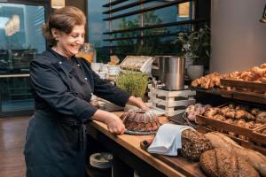 a woman standing behind a counter in a bakery at Courtyard by Marriott Munich City Center in Munich