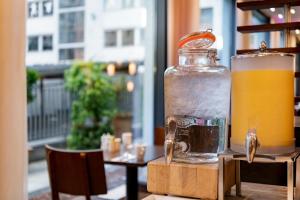 a glass jar of orange juice sitting on a table at Courtyard by Marriott Munich City Center in Munich