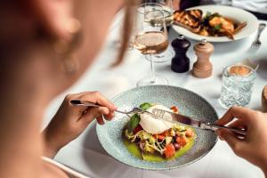 a woman sitting at a table eating a bowl of food at Courtyard by Marriott Munich City Center in Munich