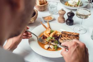 a man sitting at a table with a plate of food at Courtyard by Marriott Munich City Center in Munich
