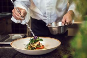 a chef is preparing a dish in a bowl at Courtyard by Marriott Munich City Center in Munich
