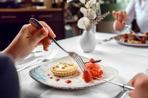a person eating food on a plate with a fork and knife at Courtyard by Marriott Munich City Center in Munich
