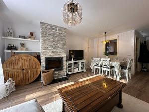 a living room with a table and a fireplace at El Escondite De Las Margas in Sabiñánigo