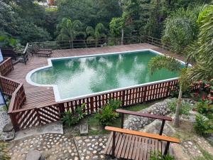 a swimming pool on a wooden deck with a bench at 4 Pozos Tayrona in Calabazo