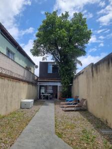 two photos of a house with a tree and a sidewalk at Casa PG na Arvore Hidro Praia in Praia Grande