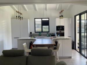 a kitchen with a table and chairs in a kitchen at Les Lodges de Malendure in Bouillante