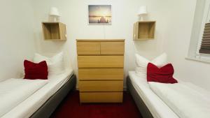 2 Betten in einem Zimmer mit roten Kissen darauf in der Unterkunft Ferienwohnung Felix am See in Joachimsthal
