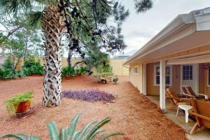 eine Giraffe neben einem Baum neben einem Haus in der Unterkunft Sunshine Cottage in Santa Rosa Beach