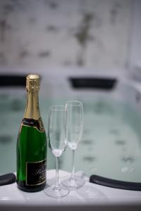 a bottle of champagne and two wine glasses on a table at Hotel Koruna in Chlumec nad Cidlinou