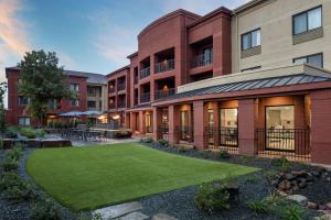 a building with a lawn in front of it at Courtyard Minneapolis St. Paul/Roseville in Roseville
