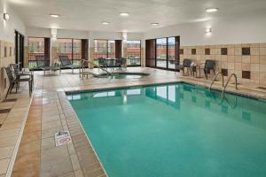 a pool in a hotel with tables and chairs at Courtyard Minneapolis St. Paul/Roseville in Roseville