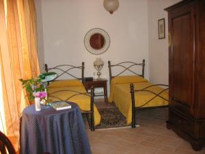 een slaapkamer met 2 aparte bedden en een tafel met een sidx sidx bij S'Arenarju in La Caletta