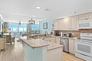 a kitchen with white cabinets and a view of the ocean at Jade East Towers 0630 by Newman-Dailey in Destin