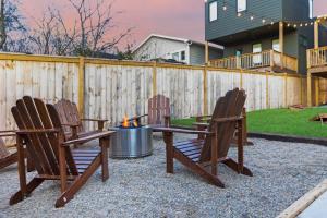 a patio with three chairs and a fire pit at The Lyric - New Luxury Home, Rooftop with Firepit! in Nashville