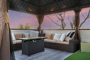a screened in porch with a couch and a table at The Lyric - New Luxury Home, Rooftop with Firepit! in Nashville