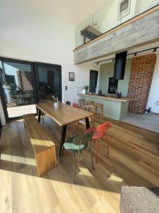 Rumiane pola - stodoła na Mazurach z widokiem na jezioro في Brajniki: غرفة معيشة مع طاولة وكراسي خشبية