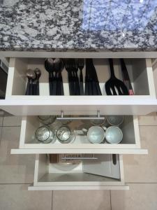 a white cabinet filled with lots of utensils at Departamentos Capernaum in Santa Rosa