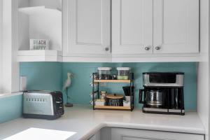 a kitchen with white cabinets and a counter with a microwave at Heated Pool 5Mins to Beach 4Bed-2Bath King Bed in Largo
