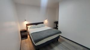 a bedroom with a bed in a white room at Bambu hostal - Alojamiento a pasos del mall y centro in Los Ángeles